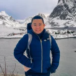 Profile image of Northern Lights tour guide Zeline outdoors near a fjord surrounded by snow-covered mountains.